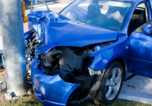 A blue car has been damaged in a car accident and requires insurance coverage in California.