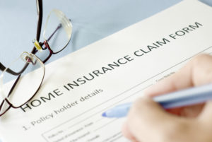 A person filling out a home insurance claim form.